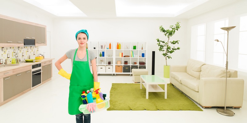 young caucasian woman standing in clean house holding cleaning products